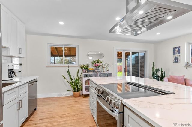 a kitchen with stainless steel appliances granite countertop a sink stove and cabinets