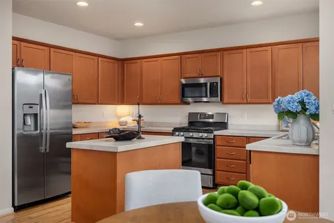 a kitchen with stainless steel appliances granite countertop a stove a sink and a refrigerator