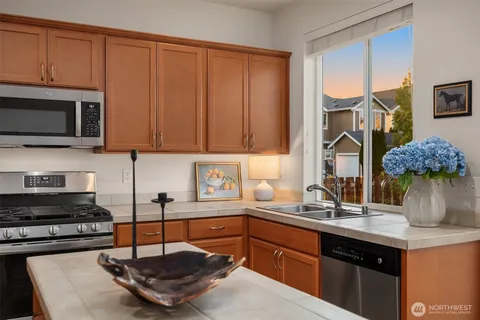 a kitchen with kitchen island granite countertop a sink stainless steel appliances and cabinets