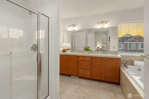 a bathroom with a tub a sink and a large window