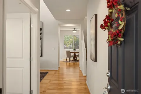 a view of a hallway with wooden floor and a potted plant