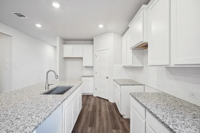 a kitchen with white cabinets a sink and dishwasher
