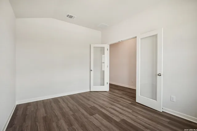a view of an empty room with wooden floor