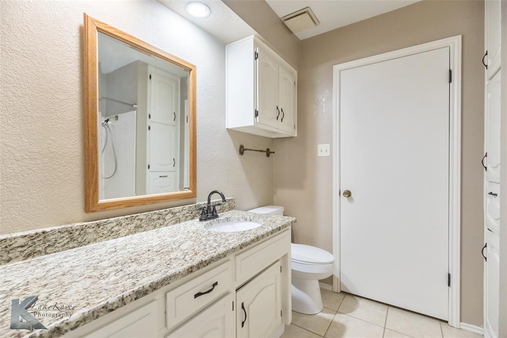 42 Riviera Circle Abilene, TX 79606 - Photo 25 of 39 a bathroom with a granite countertop sink a toilet and a mirror