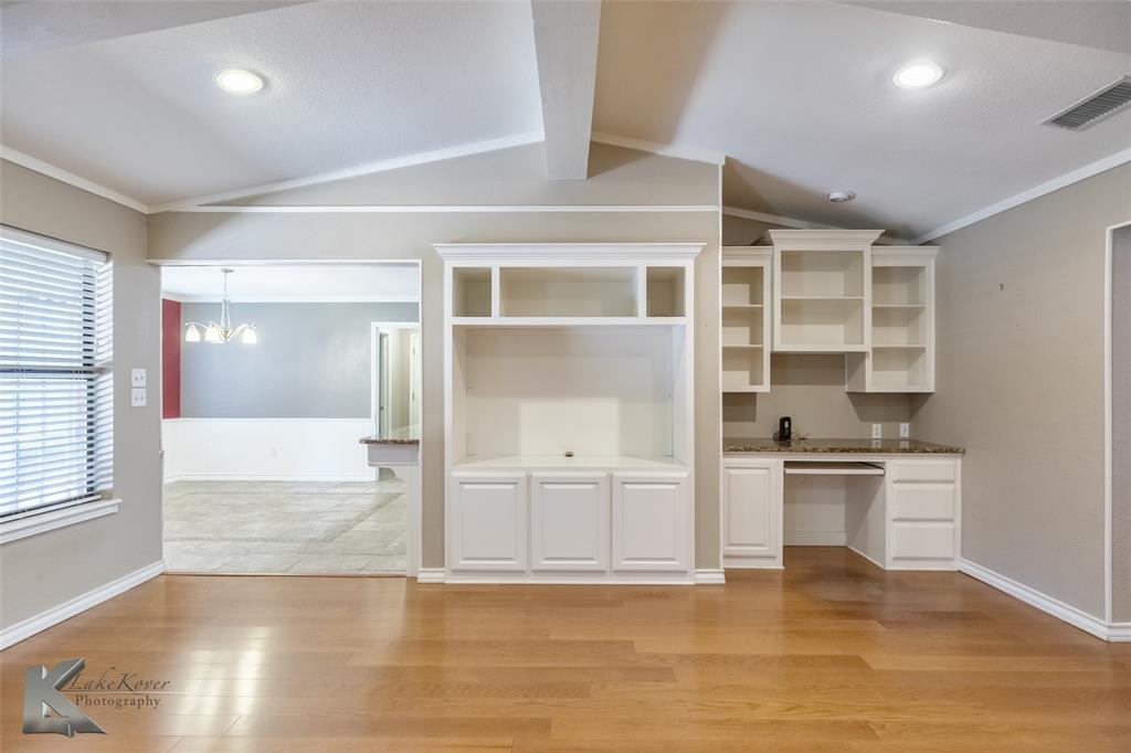 42 Riviera Circle Abilene, TX 79606 - Photo 9 of 39 an empty room with wooden floor and kitchen view
