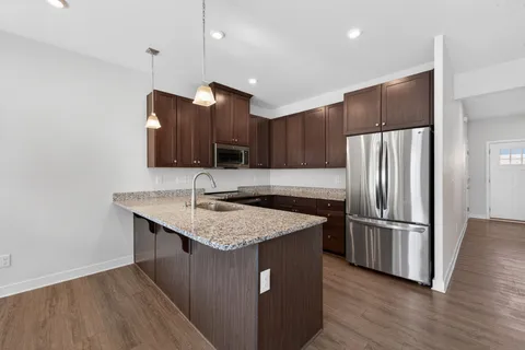 a kitchen with stainless steel appliances granite countertop a sink stove and refrigerator