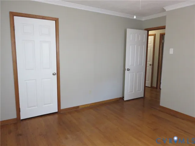 an empty room with wooden floor and closet area