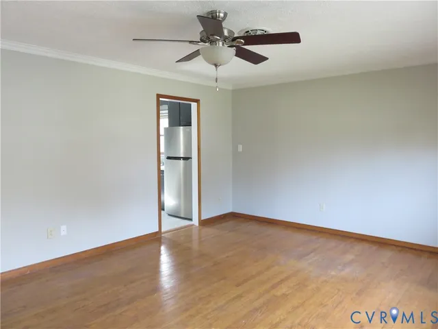 a view of an empty room with a ceiling fan and a window