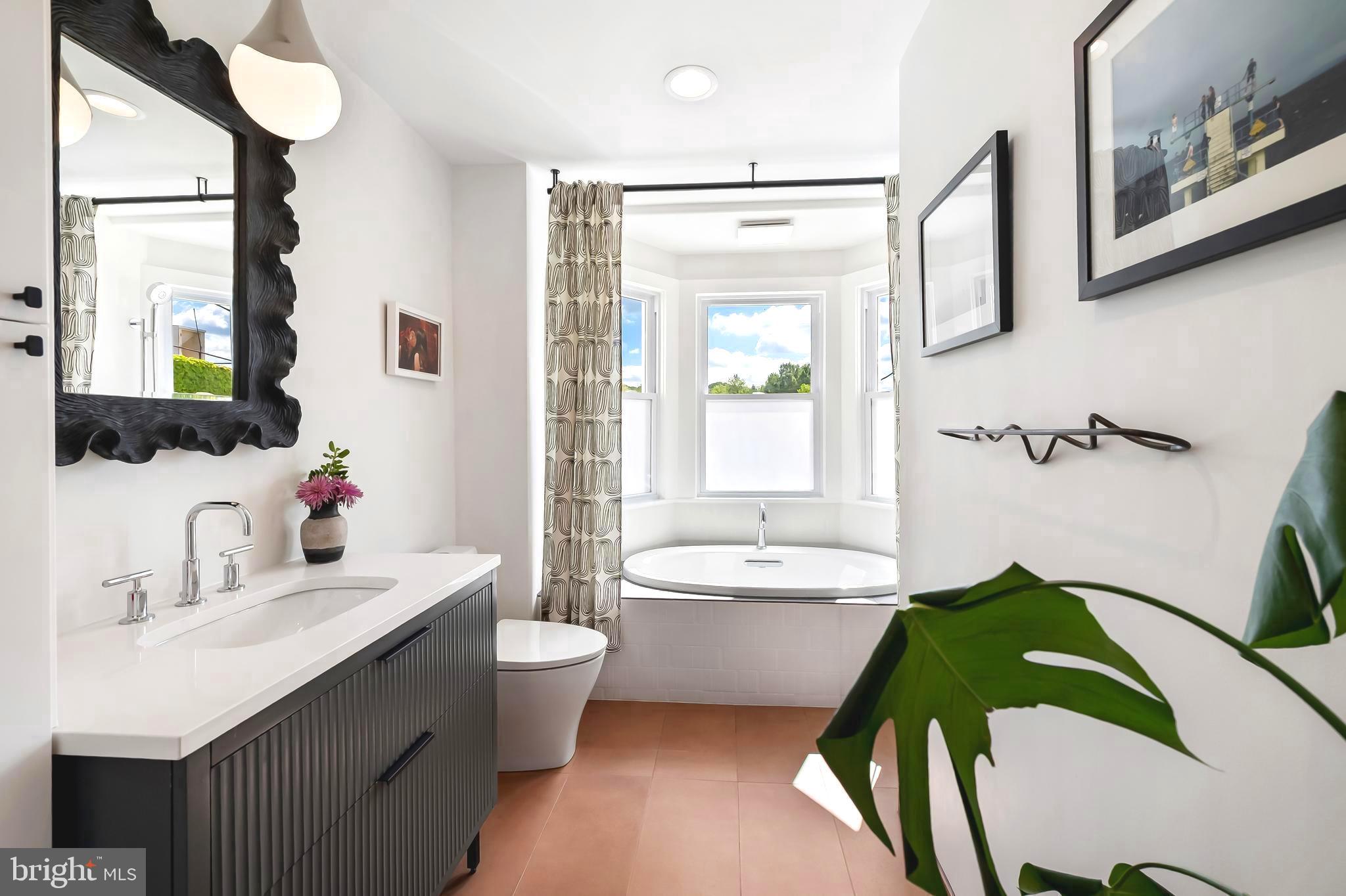 a bathroom with a double vanity sink mirror and bathtub