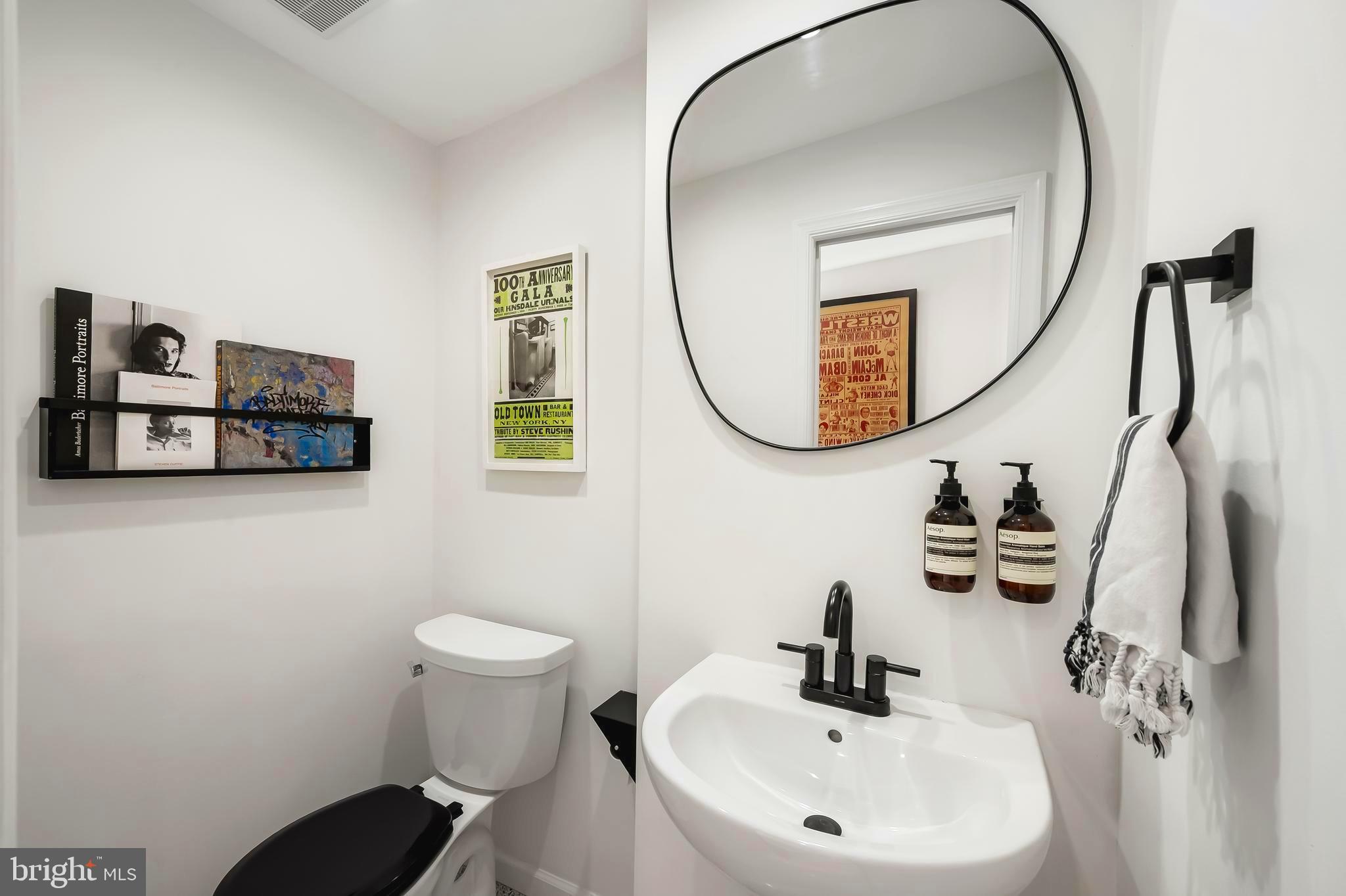 3409 Keswick Road Baltimore, MD 21211 - Photo 20 of 49 a bathroom with a toilet a sink and mirror
