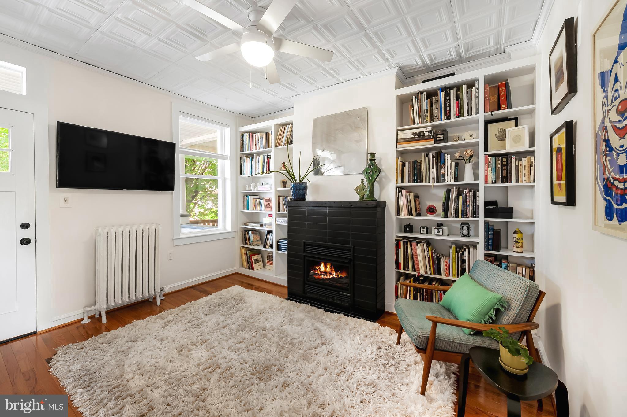 3409 Keswick Road Baltimore, MD 21211 - Photo 9 of 49 a living room with fireplace furniture and a flat screen tv