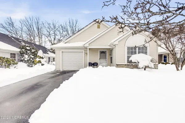 a view of a white house with a yard covered in snow