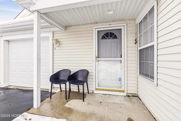 a front view of a house with a glass door and furniture