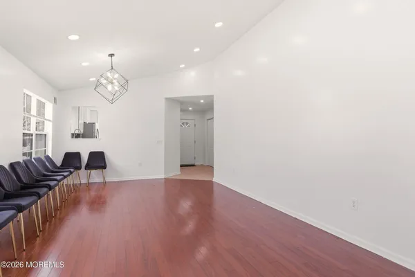a view of a livingroom with furniture wooden floor windows and a chandelier