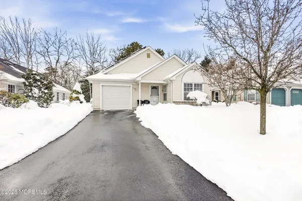 a view of a white house with a yard covered in snow