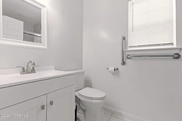 a bathroom with a toilet sink vanity and mirror