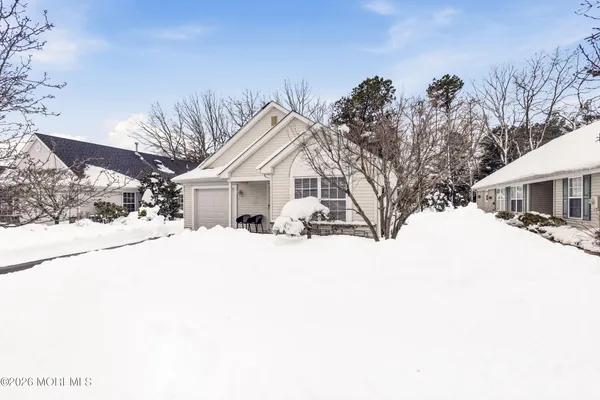 a view of a white house with a snow on the road