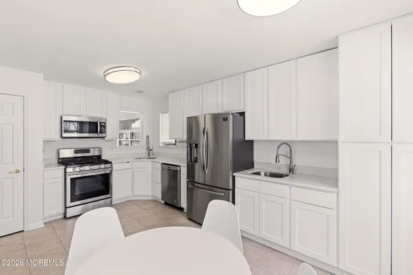 a kitchen with stainless steel appliances granite countertop a refrigerator sink stove microwave and cabinets