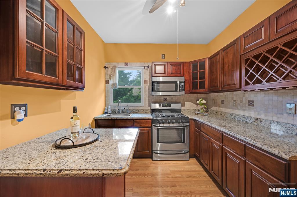 119 High Street Passaic, NJ 07055 - Photo 15 of 38 a kitchen with stainless steel appliances granite countertop a stove a sink and a microwave