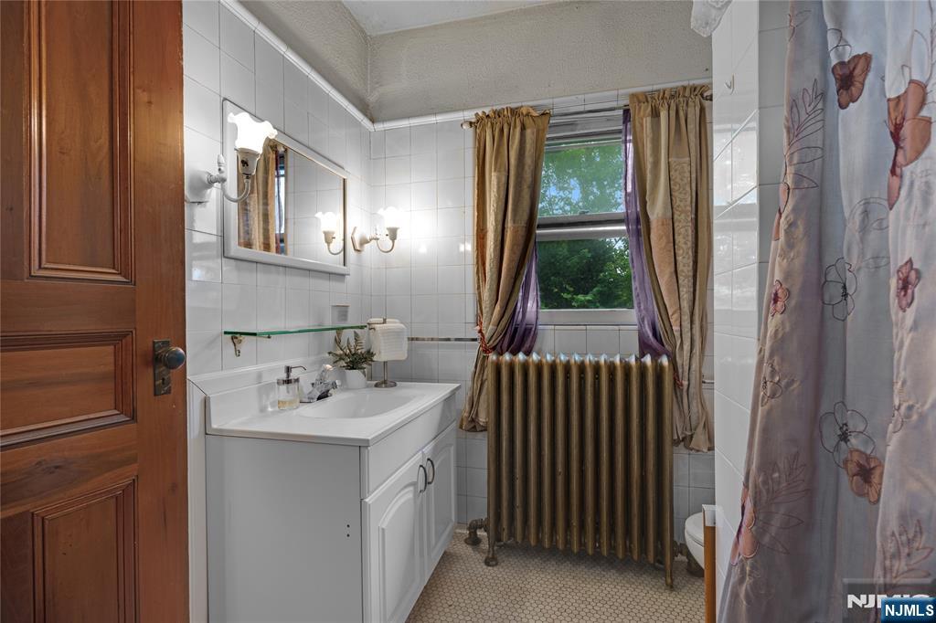 119 High Street Passaic, NJ 07055 - Photo 20 of 38 a bathroom with a sink a mirror and a window