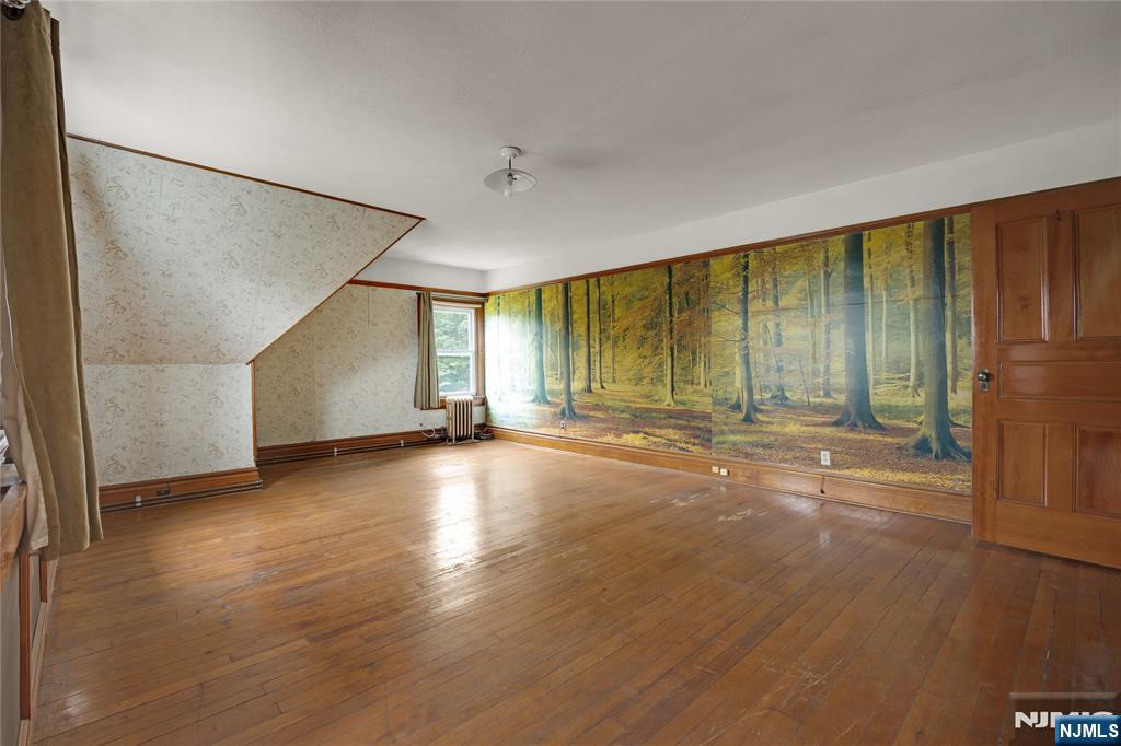 119 High Street Passaic, NJ 07055 - Photo 30 of 38 an empty room with wooden floor and windows with curtains