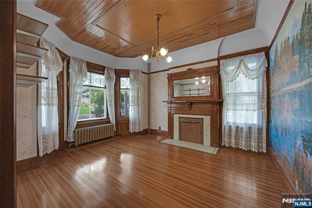 119 High Street Passaic, NJ 07055 - Photo 5 of 38 a view of an empty room with wooden floor fireplace and a window