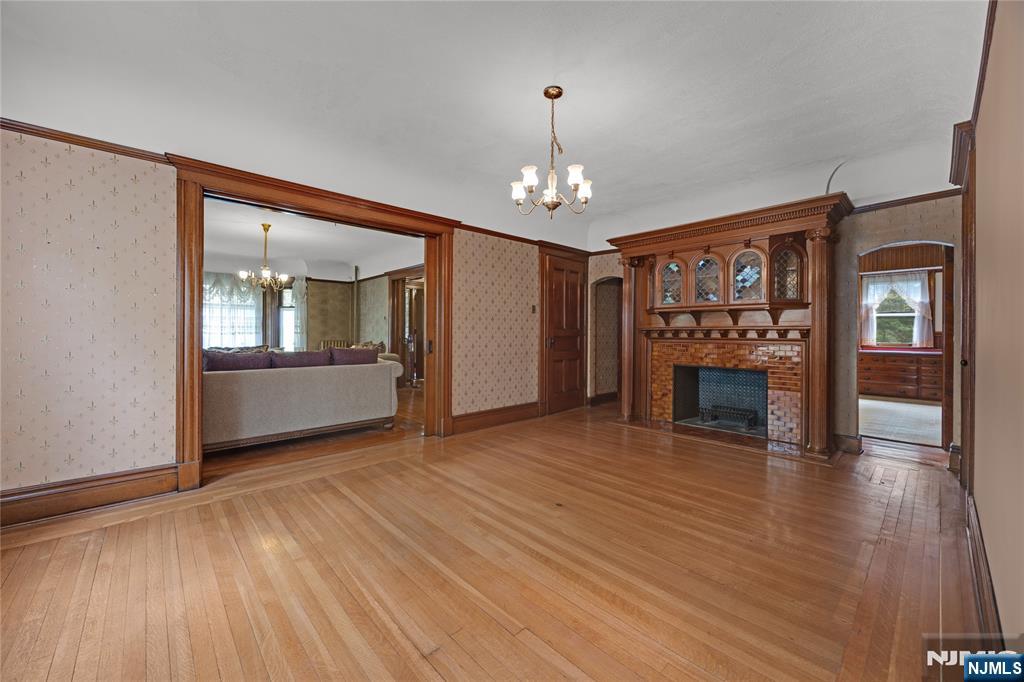 119 High Street Passaic, NJ 07055 - Photo 8 of 38 an empty room with wooden floor fireplace and cabinet
