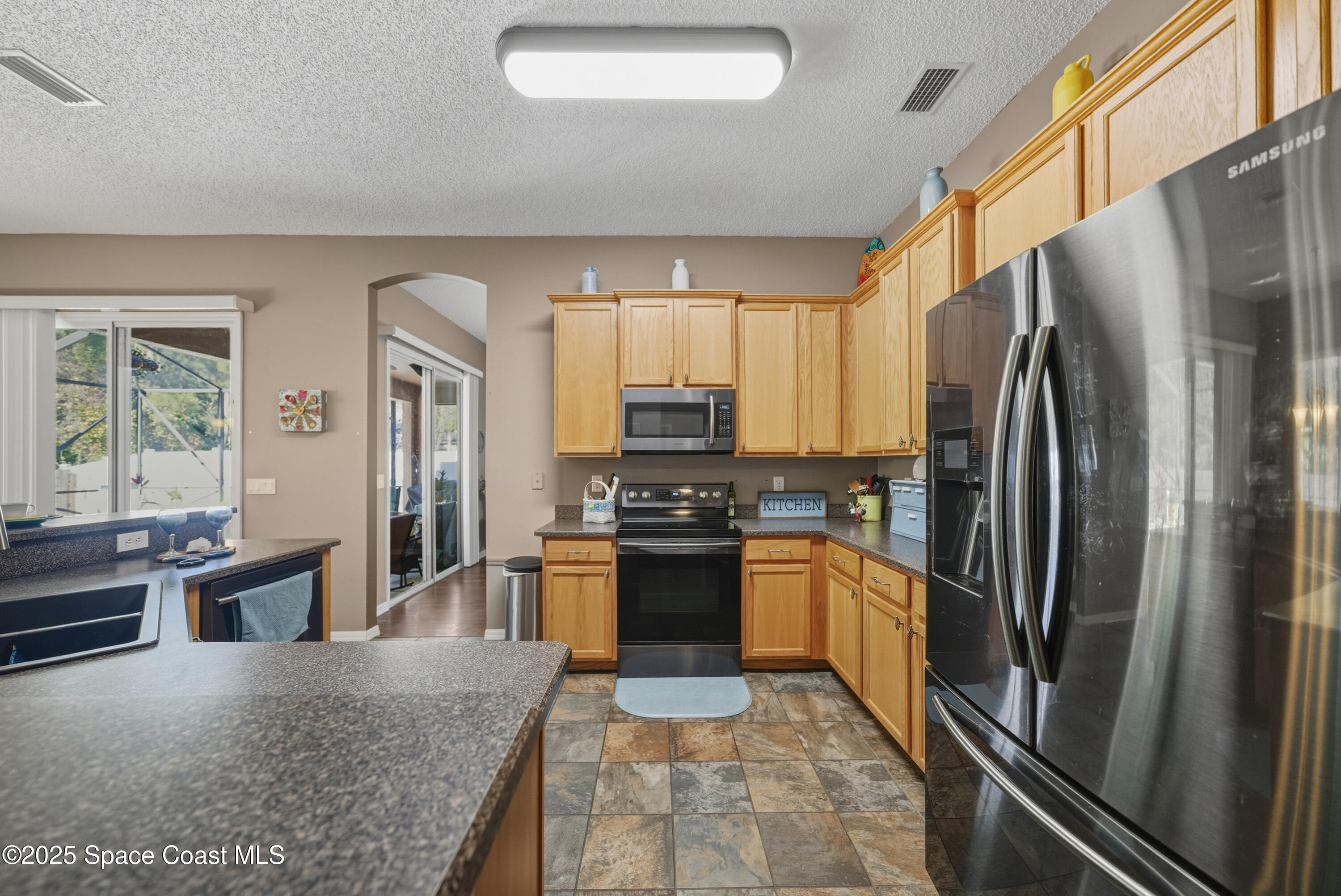 7368 Crepe Myrtle Court Cocoa, FL 32927 - Photo 11 of 50 a kitchen with stainless steel appliances granite countertop a refrigerator stove and oven