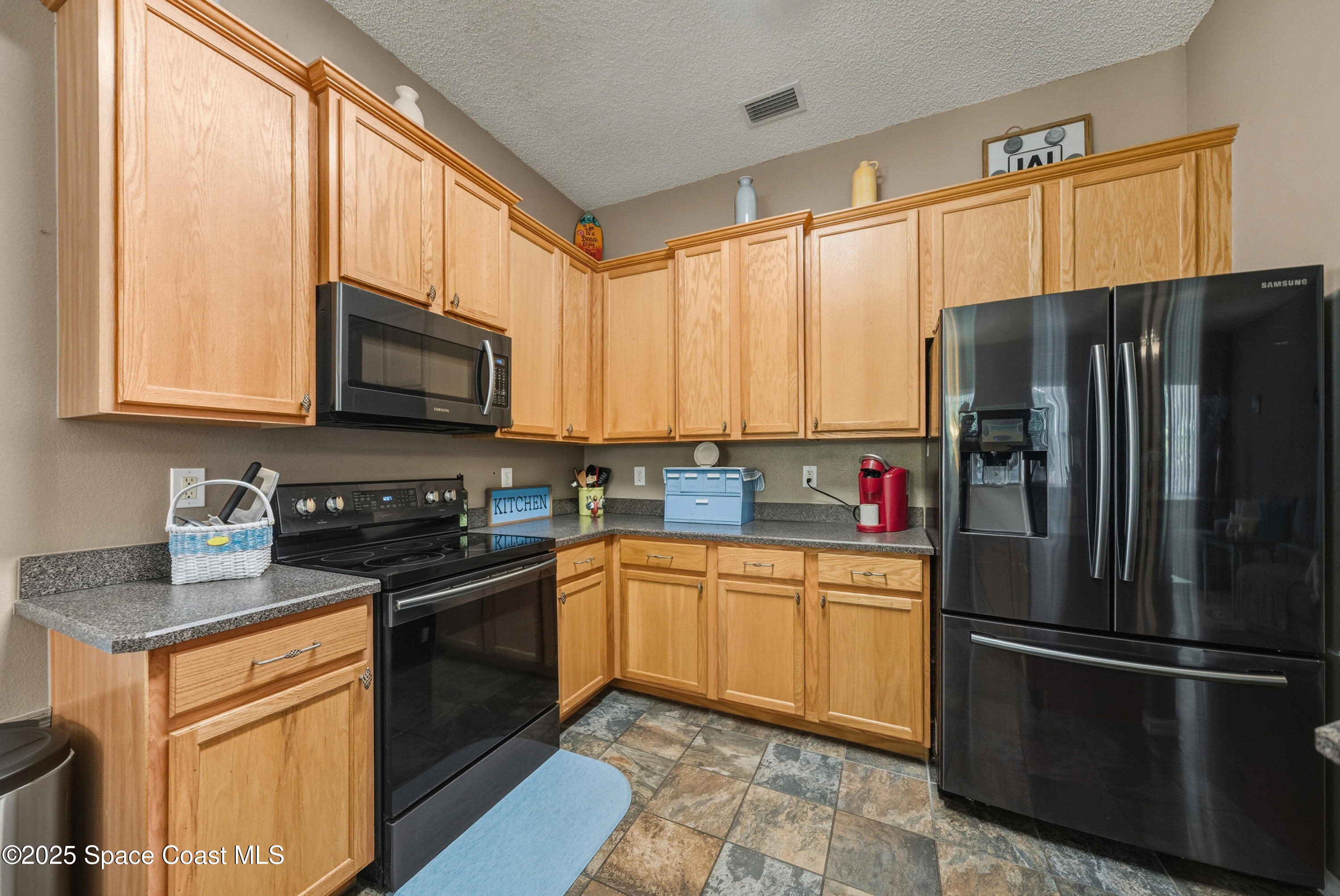 7368 Crepe Myrtle Court Cocoa, FL 32927 - Photo 12 of 50 a kitchen with stainless steel appliances a refrigerator sink and microwave