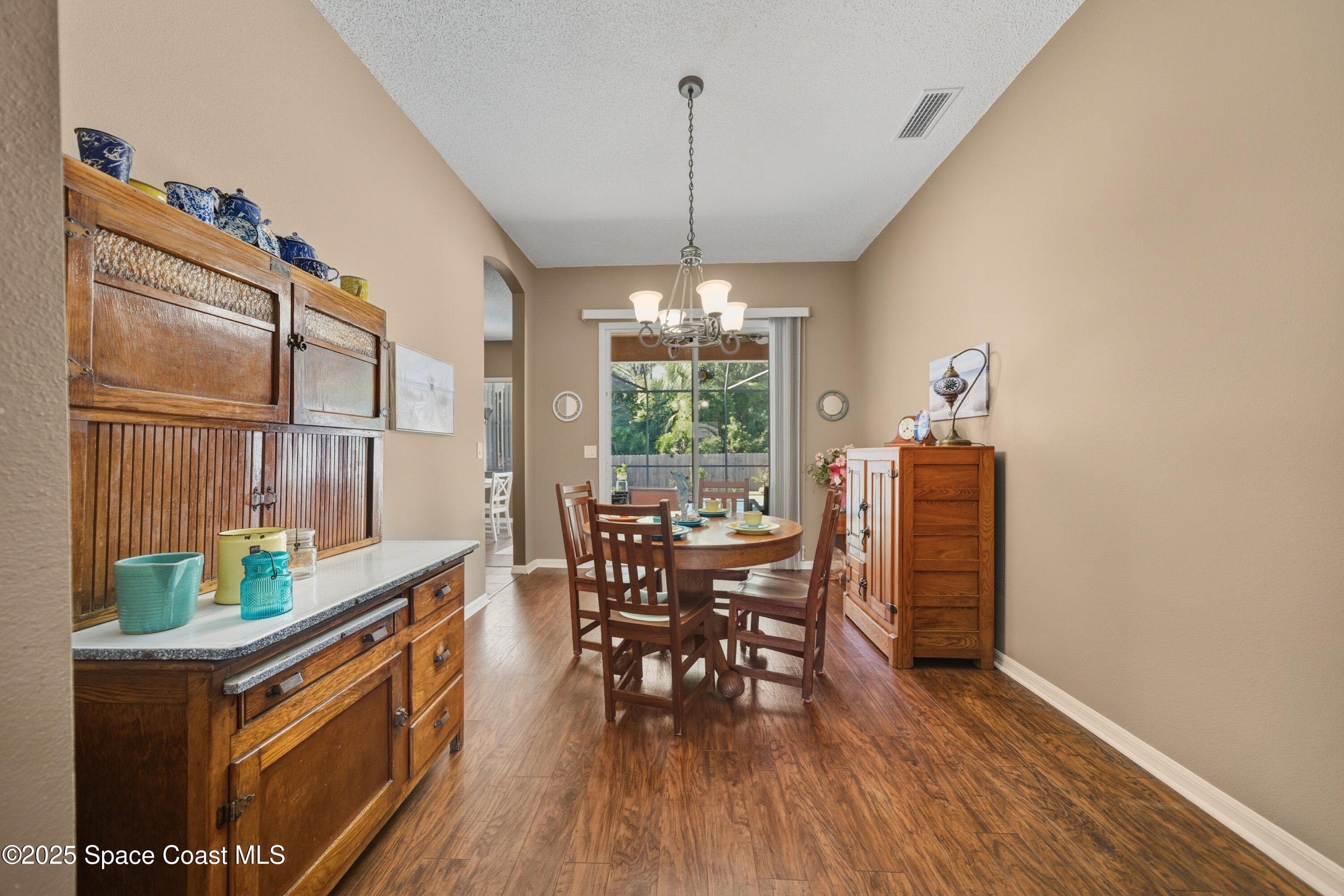 7368 Crepe Myrtle Court Cocoa, FL 32927 - Photo 18 of 50 a dining room with furniture window wooden floor and a chandelier