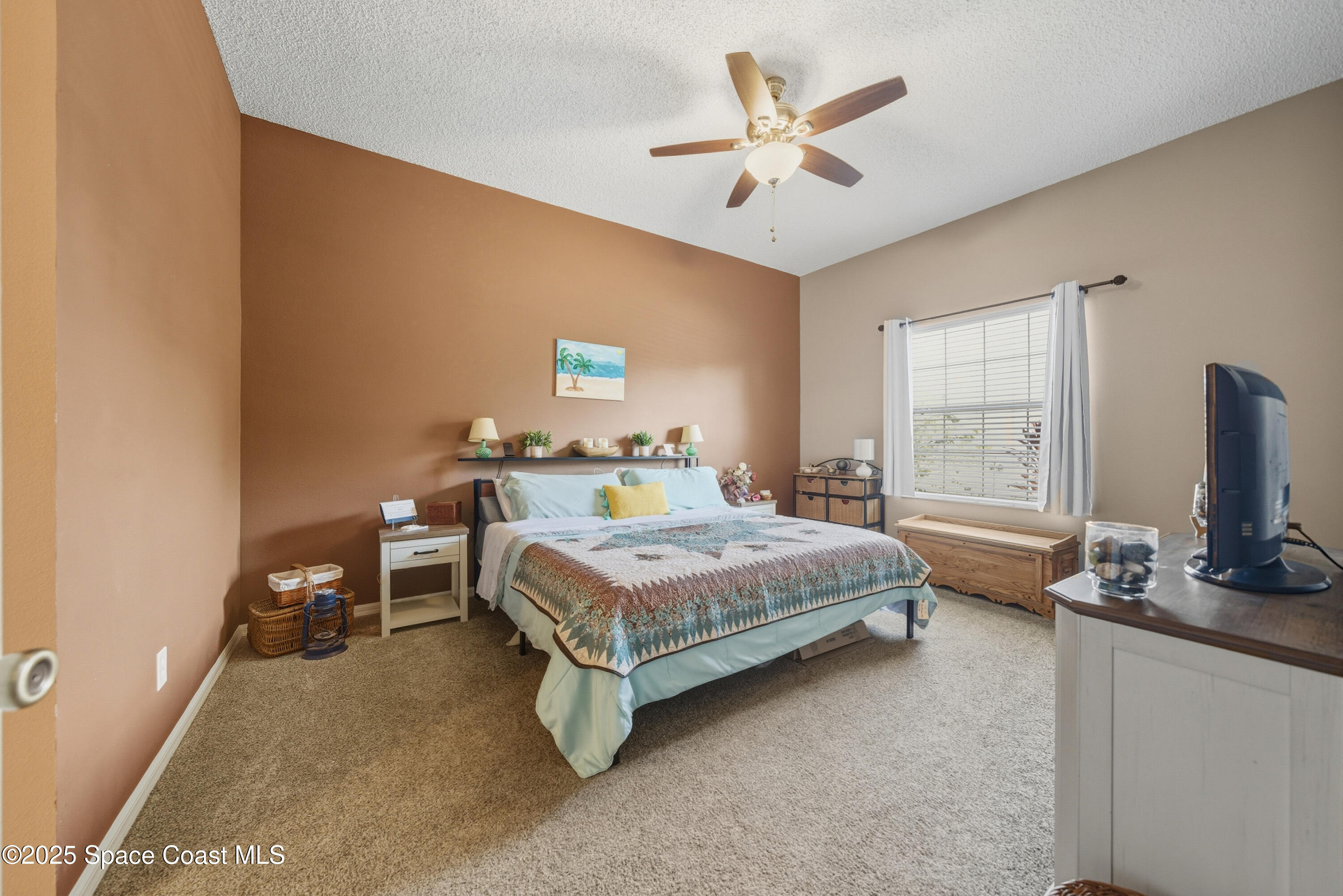 7368 Crepe Myrtle Court Cocoa, FL 32927 - Photo 20 of 50 a bedroom with a bed a chair and a chandelier
