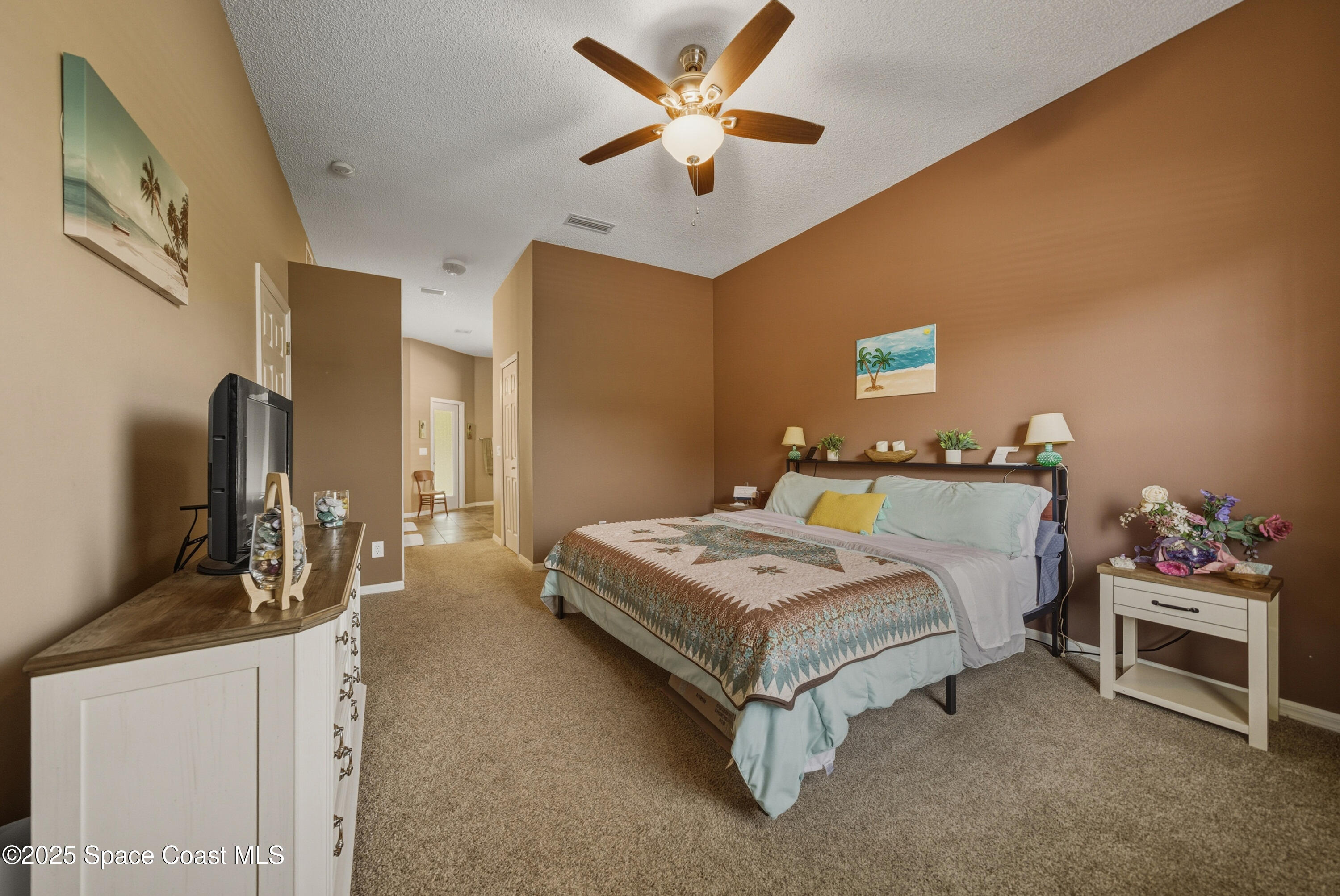 7368 Crepe Myrtle Court Cocoa, FL 32927 - Photo 21 of 50 a bedroom with a bed and a chandelier