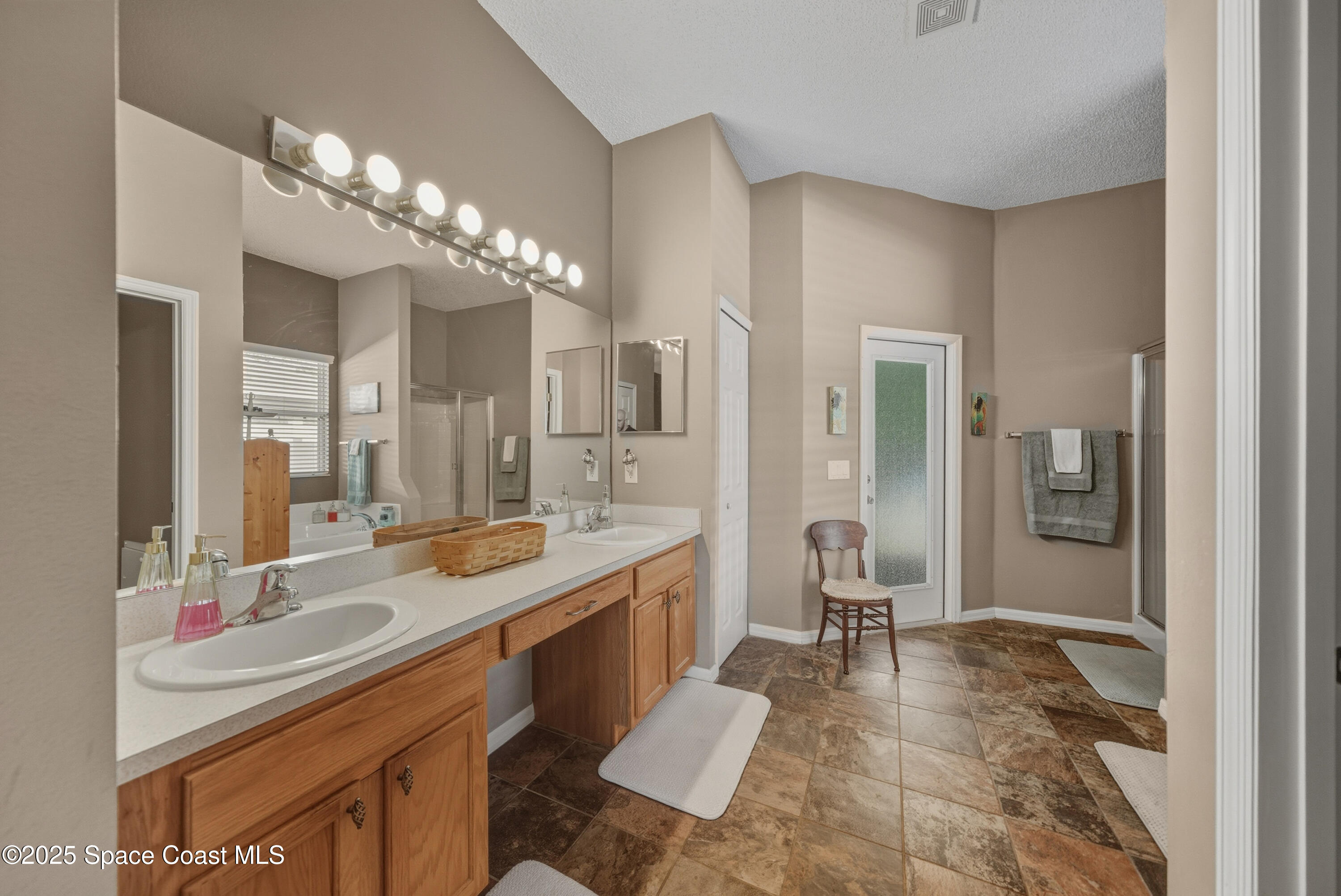 7368 Crepe Myrtle Court Cocoa, FL 32927 - Photo 22 of 50 a large bathroom with a sink a large mirror and a shower