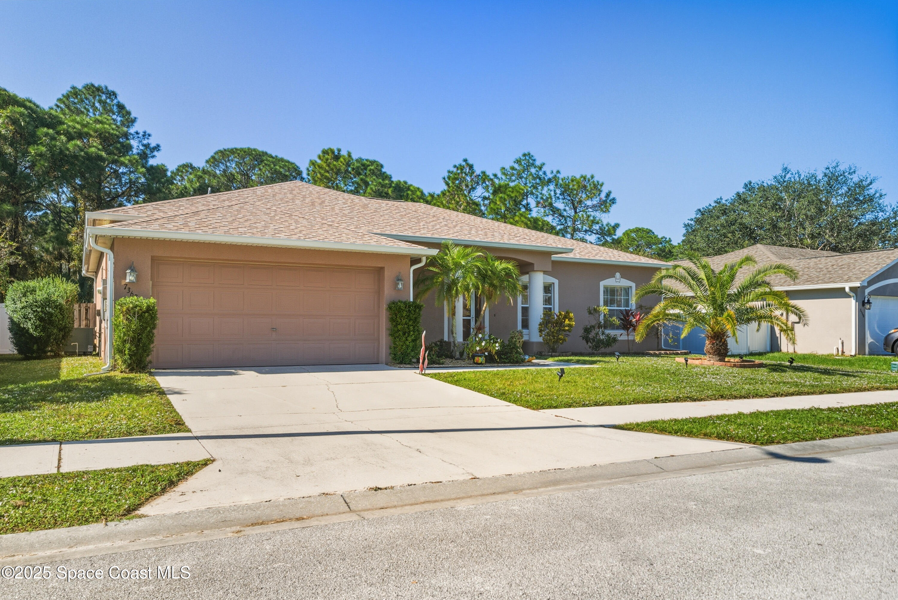 7368 Crepe Myrtle Court Cocoa, FL 32927 - Photo 47 of 50 a front view of a house with a yard and garage