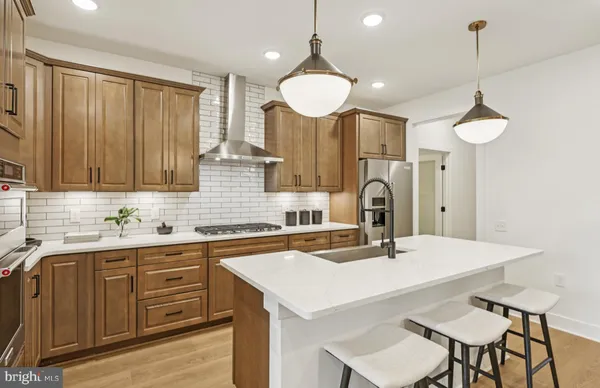 a kitchen with a sink a stove and chairs