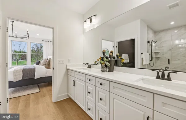 a bathroom with a double vanity sink a mirror and a bathtub