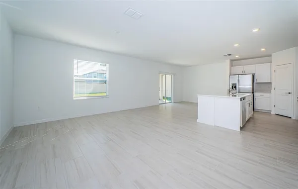 a view of empty room with wooden floor and window