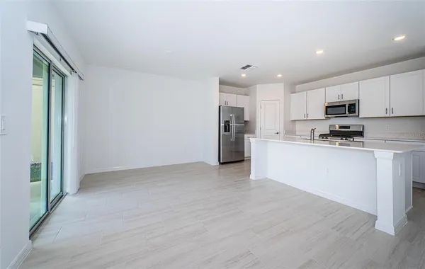 a view of kitchen with wooden floor and electronic appliances