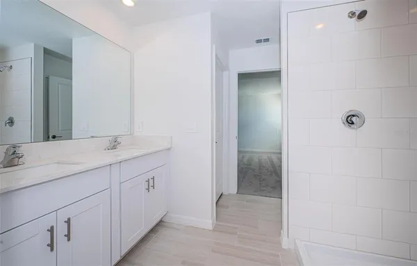 a bathroom with a double vanity sink and mirror