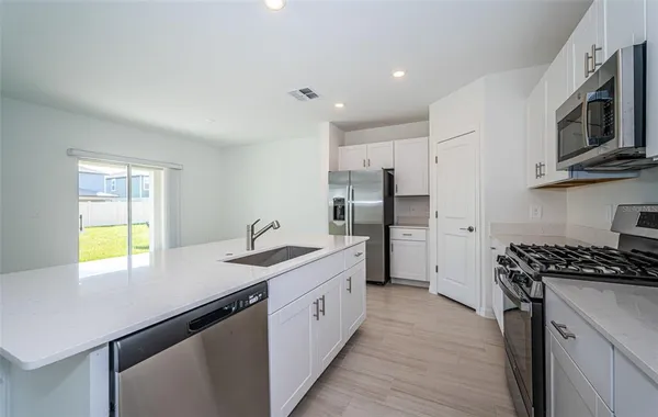 a kitchen with stainless steel appliances granite countertop a sink stove and refrigerator