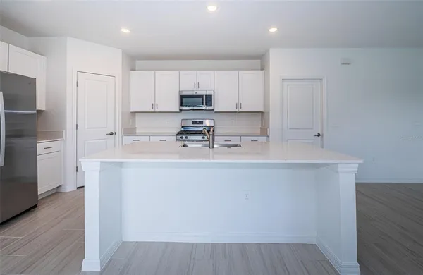a room with stainless steel appliances white cabinets and wooden floor