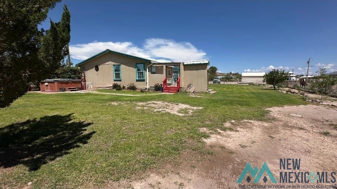 4 Midway Road Caballo, NM 87931 - Photo 34 of 43 Rear view of house with a hot tub and a lawn