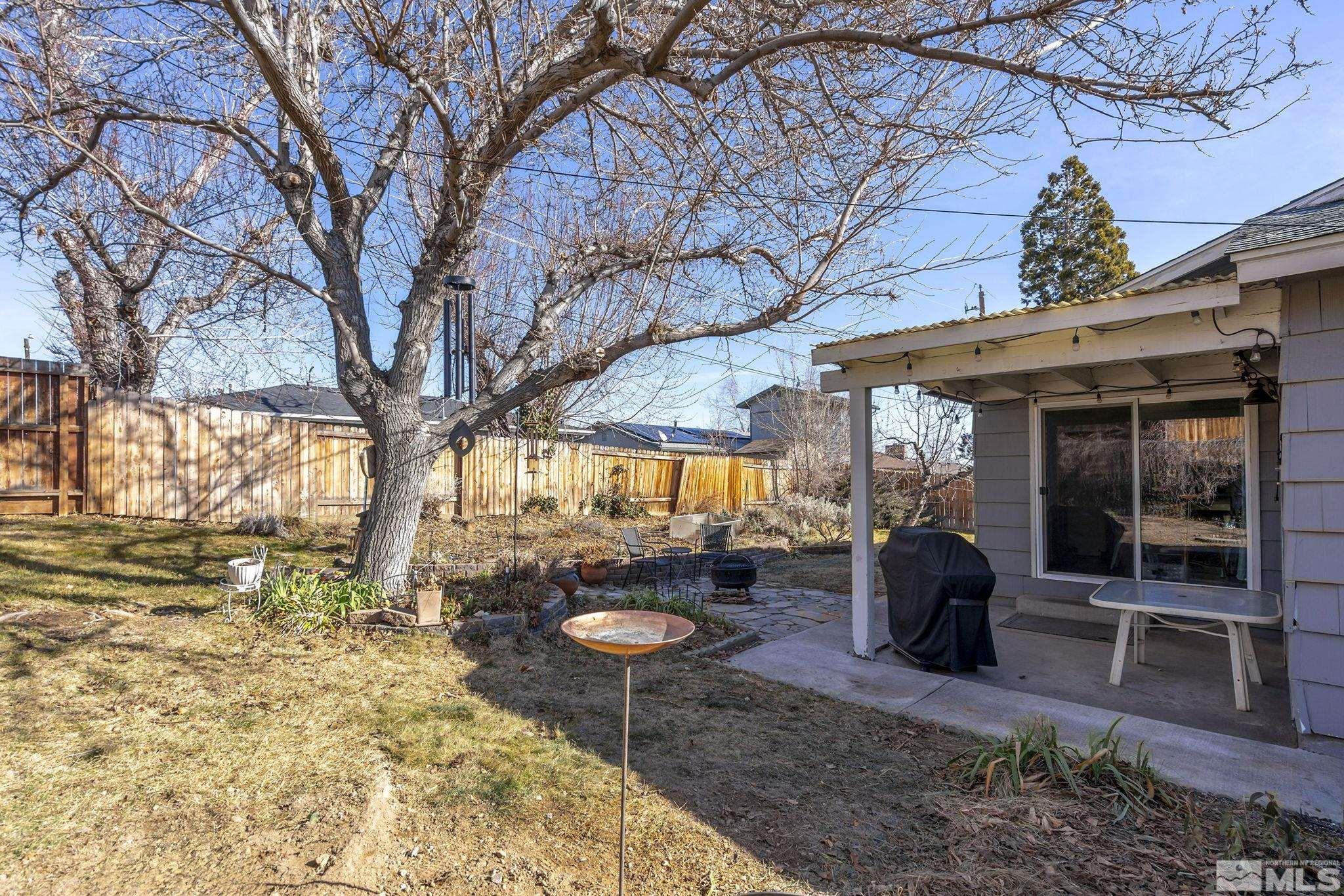 1370 Beldon Way Reno, NV 89503 - Photo 19 of 23 a view of a backyard with table and chairs and wooden fence