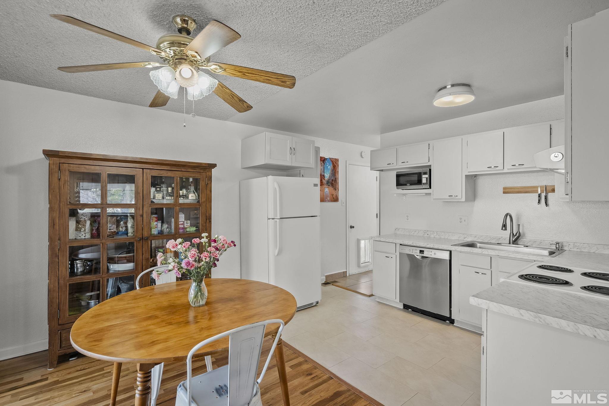 1370 Beldon Way Reno, NV 89503 - Photo 8 of 23 a kitchen with stainless steel appliances kitchen island granite countertop a table chairs and a refrigerator