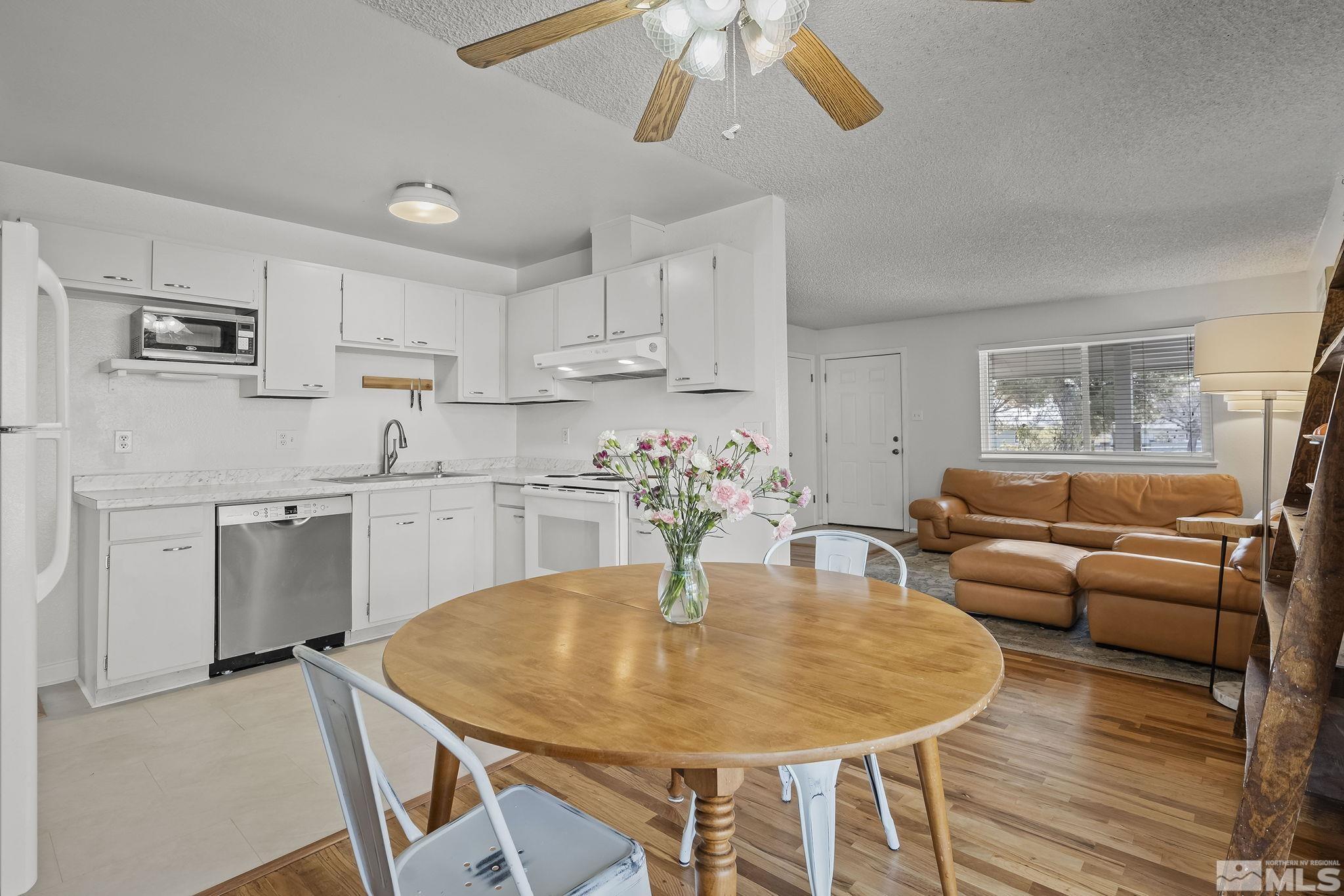 1370 Beldon Way Reno, NV 89503 - Photo 9 of 23 a kitchen with stainless steel appliances granite countertop a dining table chairs and white cabinets