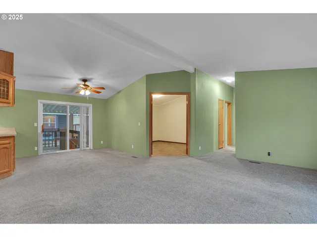 a view of an empty room with a window and fireplace