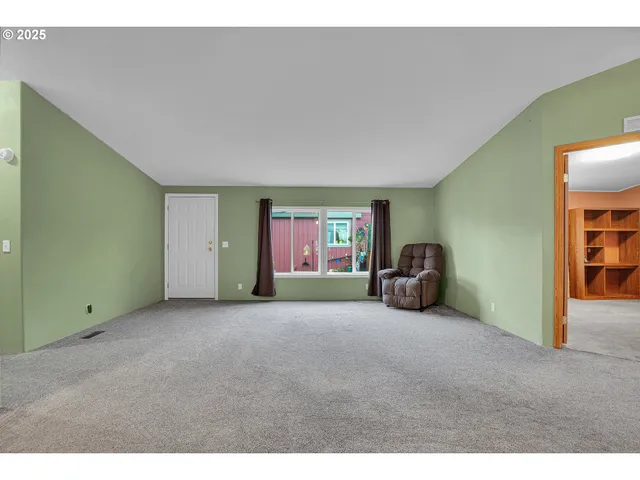 a view of a livingroom with workspace and a window