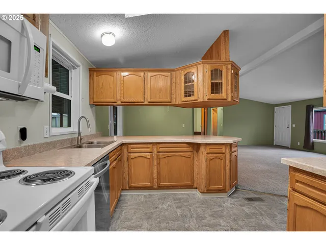 a kitchen with granite countertop a sink stove and cabinets