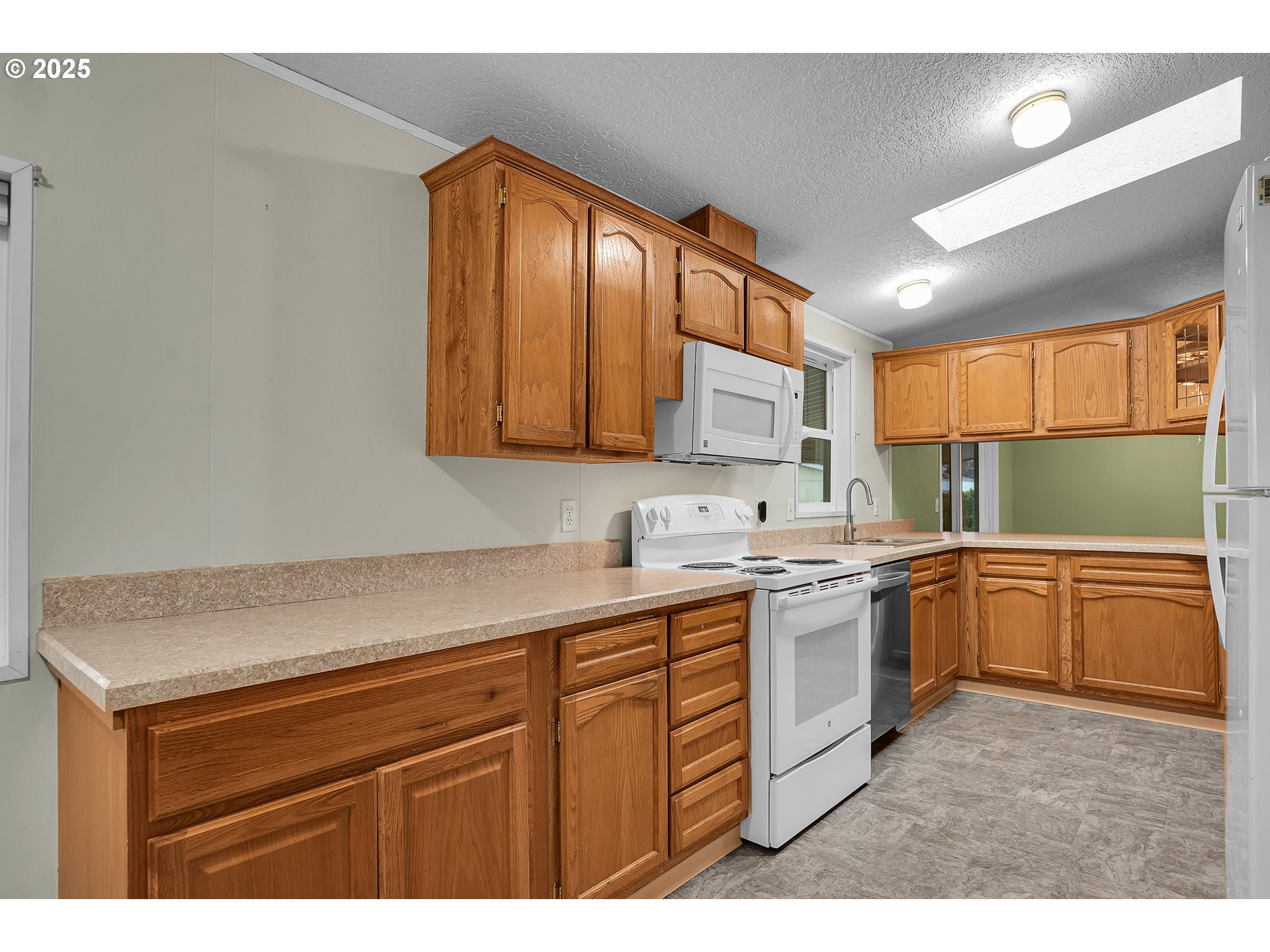 51459 Westlake Drive, Unit 102 Scappoose, OR 97056 - Photo 29 of 40 a kitchen with a sink a stove cabinets and wooden floor