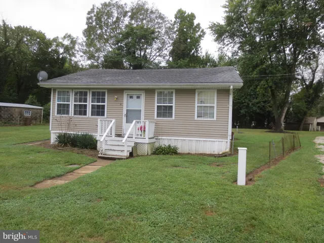 a view of a house with a yard and sitting area